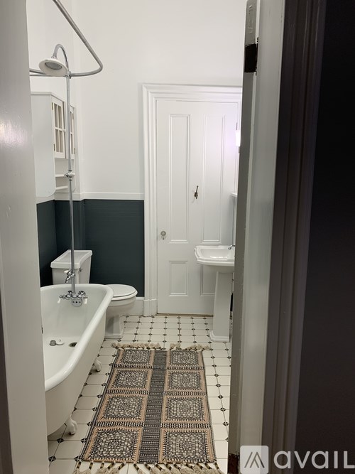 A bathroom with a white tub and a rug on the floor.