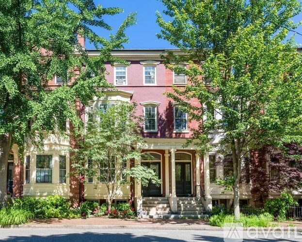 A large house with a red brick exterior and a white trim.