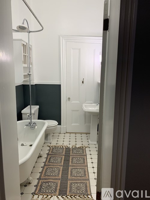 A bathroom with a white tub and a rug on the floor.