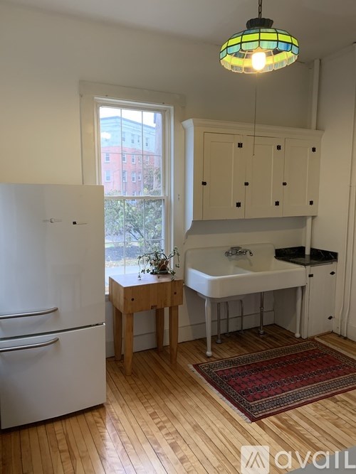 A kitchen with wooden floors and white appliances.
