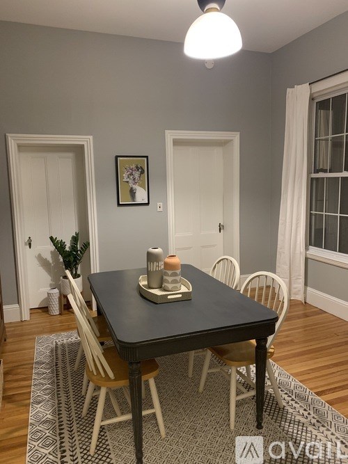 A dining table with chairs and a candle on it.