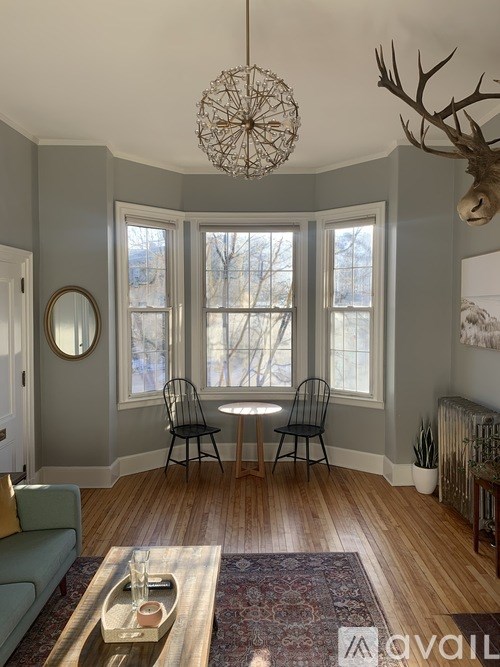 A living room with a couch, chairs, and a rug.