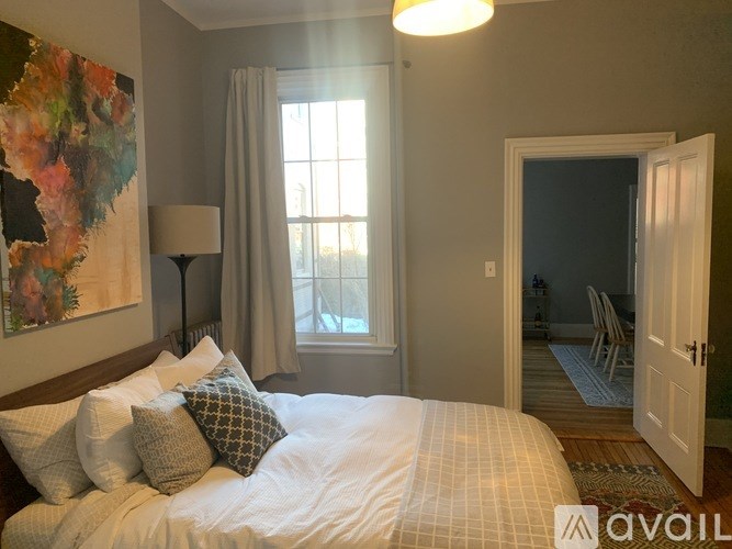 A bedroom with a large bed and a painting on the wall.