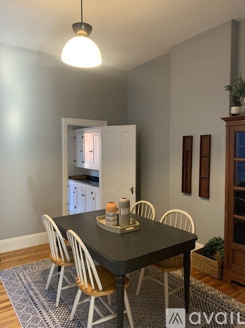 A dining room with a black table and chairs.