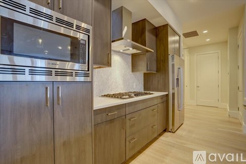 A modern kitchen with wooden cabinets and stainless steel appliances.