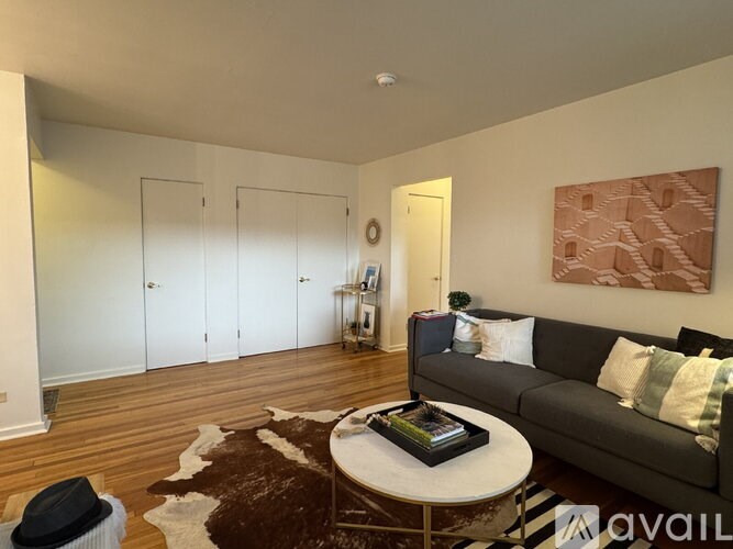 A living room with a grey couch, a coffee table, and a cowhide rug.