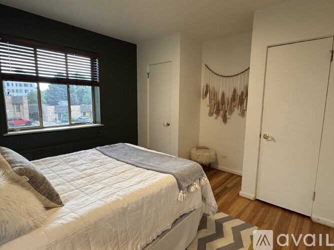 A bedroom with a large bed and a window overlooking a street.