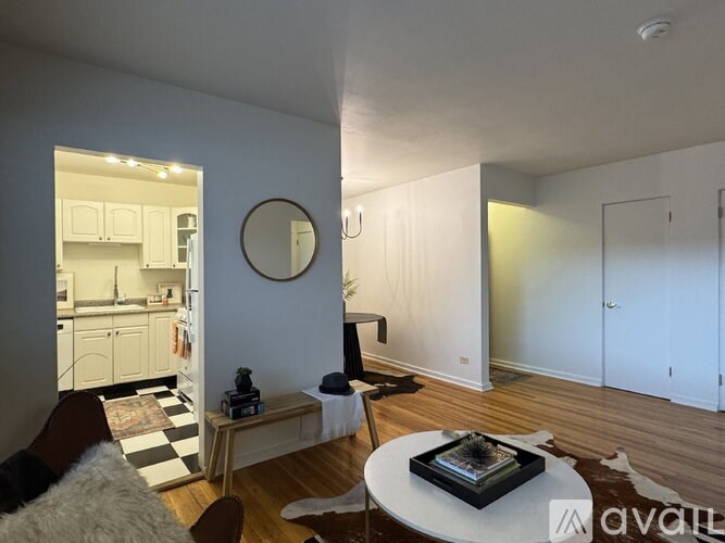 A living room with a white couch and a black and white checkered rug.