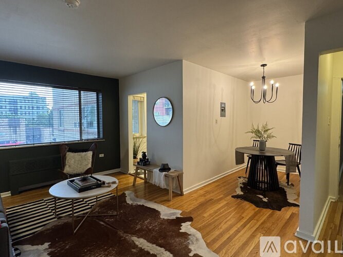 A living room with a white table and a brown cowhide rug.