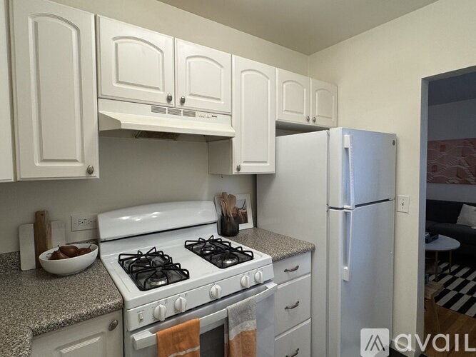 A kitchen with white cabinets and a stove top oven.