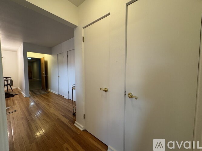A hallway with white doors and wooden floors.