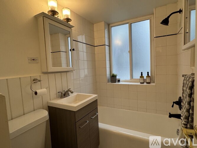 A bathroom with a white tub, sink, and mirror.