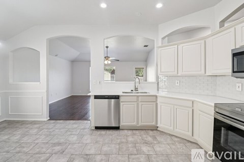 A kitchen with white cabinets and a tiled floor.