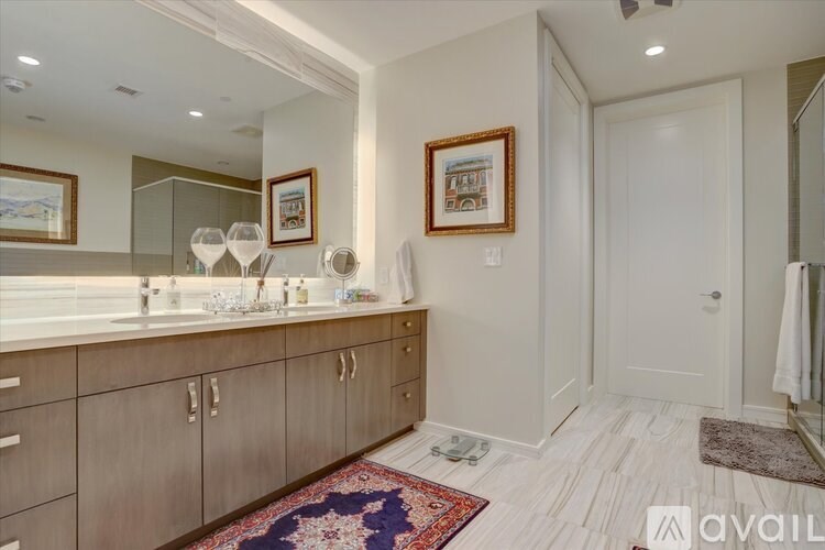A bathroom with a vanity and a rug on the floor.