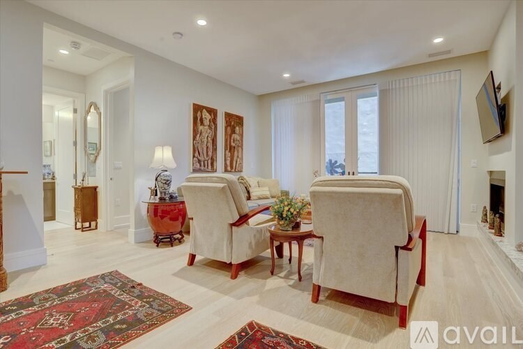 A living room with two chairs and a table in the middle.