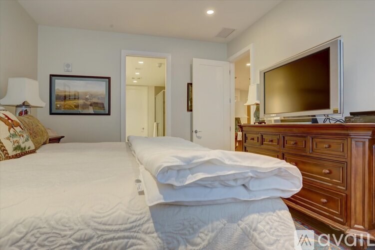 A bedroom with a large bed and a television in the corner.