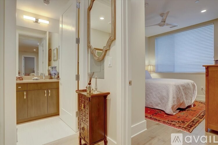 A bedroom with a large mirror and a wooden cabinet.