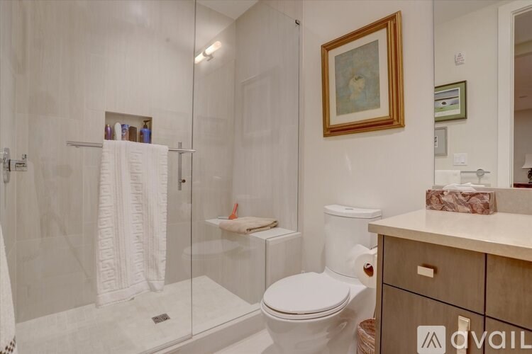 A bathroom with a toilet, sink, and shower.