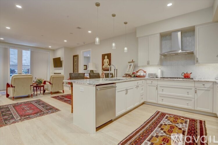 A kitchen with white cabinets and a large island.