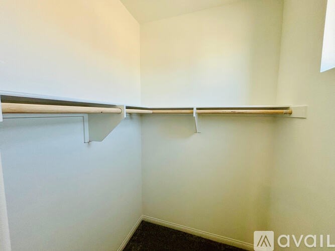 A white wall with a shelf and a black carpet.