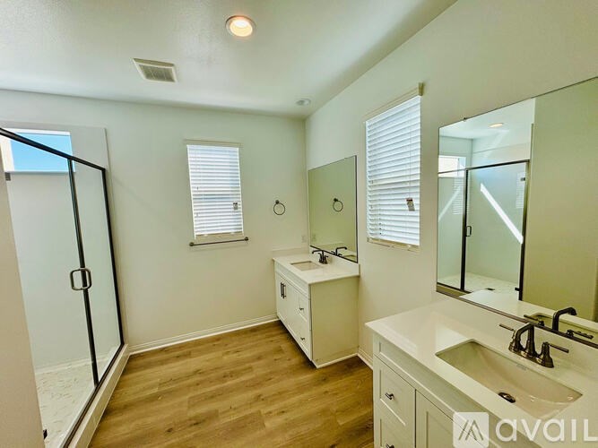 A bathroom with a sink, mirror, and shower.