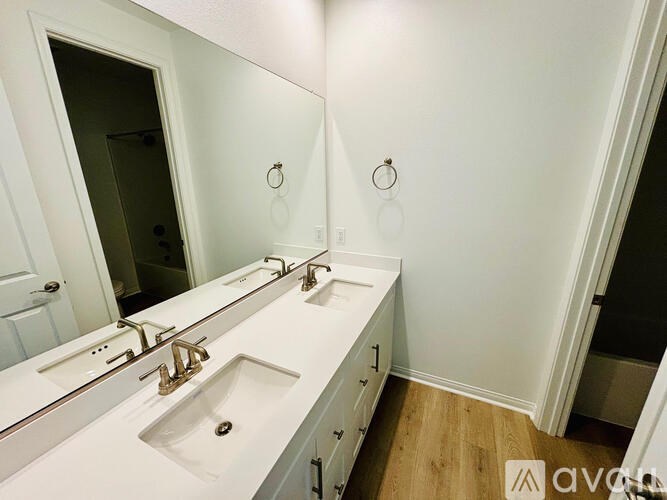 A bathroom with two sinks and a large mirror.