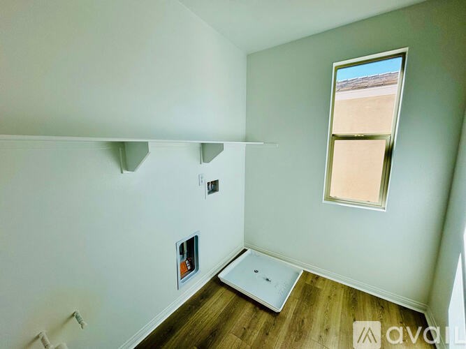 A room with a window and a picture on the wall.