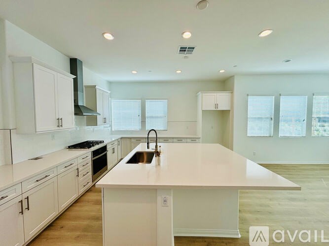 A modern kitchen with white cabinets and a large island.