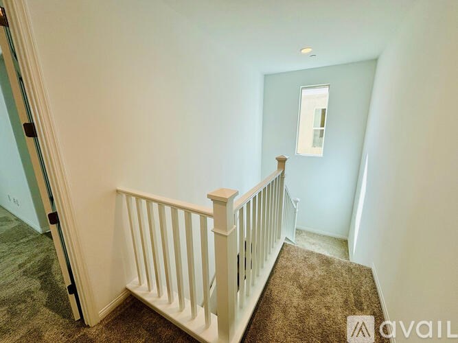 A carpeted stairway with a white railing.