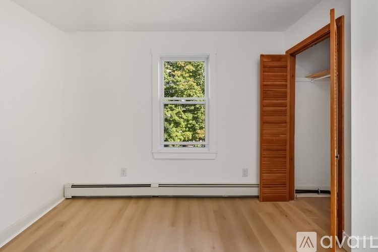 A room with a window and a wooden door.