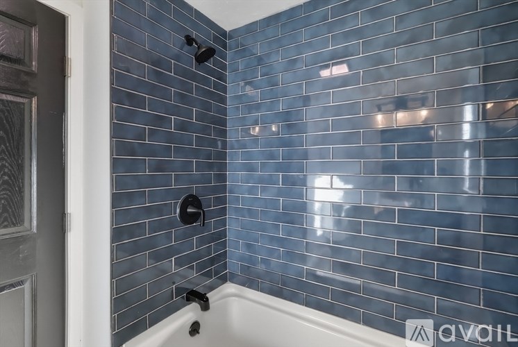 A bathroom with a blue tiled shower area.