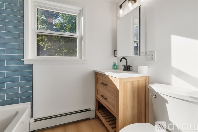 A bathroom with a white sink and a window.