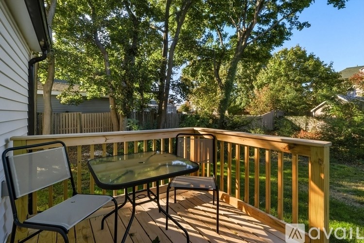 A table and two chairs are on a wooden deck.