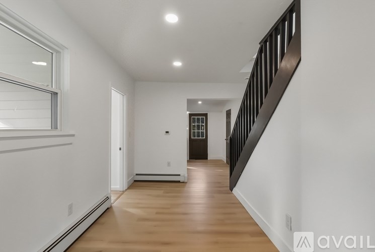 A long hallway with a black railing on the right side.