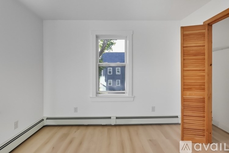 A room with a window and a wooden door.