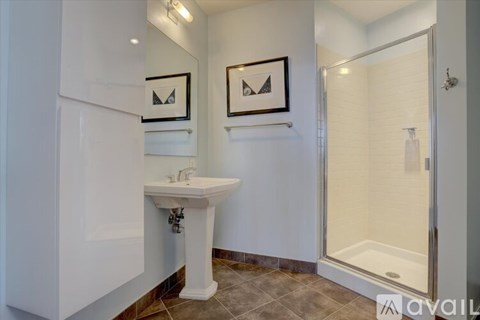 A bathroom with a sink, mirror, and shower.