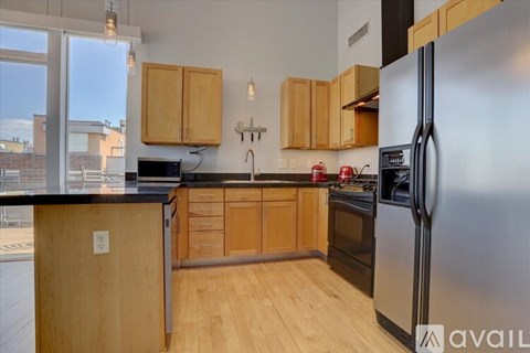 A kitchen with wooden cabinets and a black countertop.