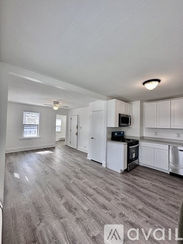 A kitchen with white cabinets and a microwave.