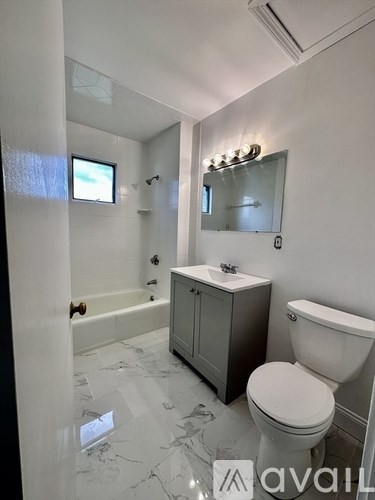 A bathroom with a toilet, sink, and bathtub.
