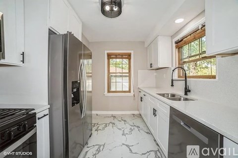 A kitchen with a refrigerator, stove, and sink.