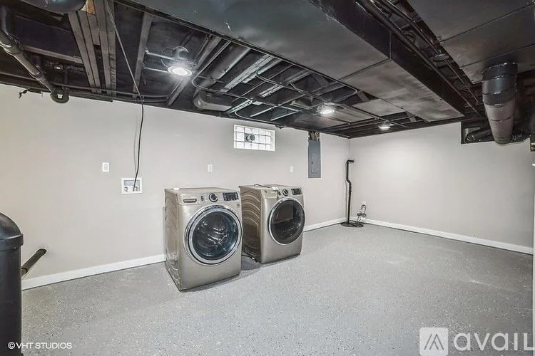 A room with two washing machines and a vacuum cleaner.