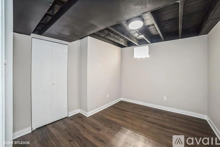 A room with wooden floors and a ceiling with exposed beams.