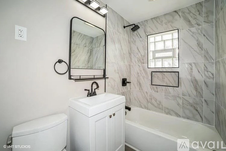 A bathroom with a white toilet, sink, and bathtub.