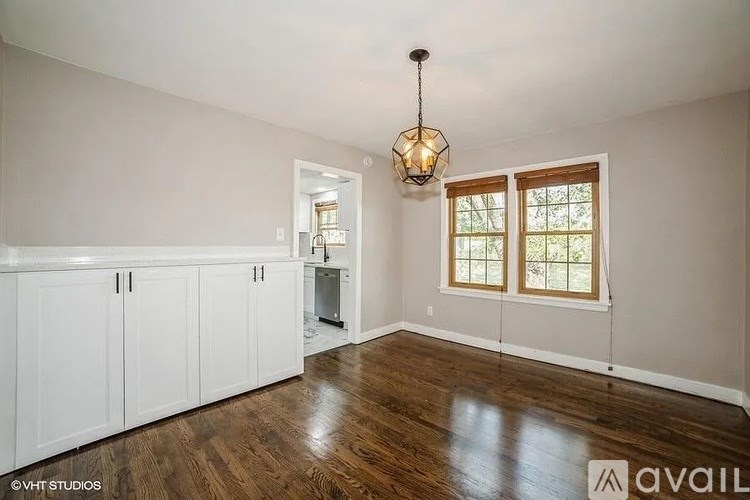 A room with wooden floors and a chandelier hanging from the ceiling.