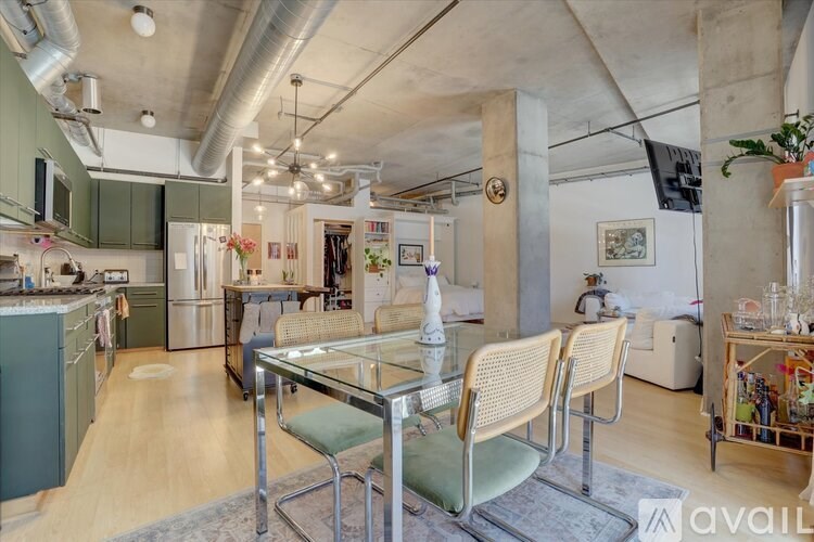 A kitchen with a dining table and chairs in the foreground.