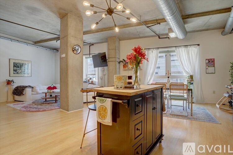 A kitchen with wooden cabinets and a large island with a clock on the wall.