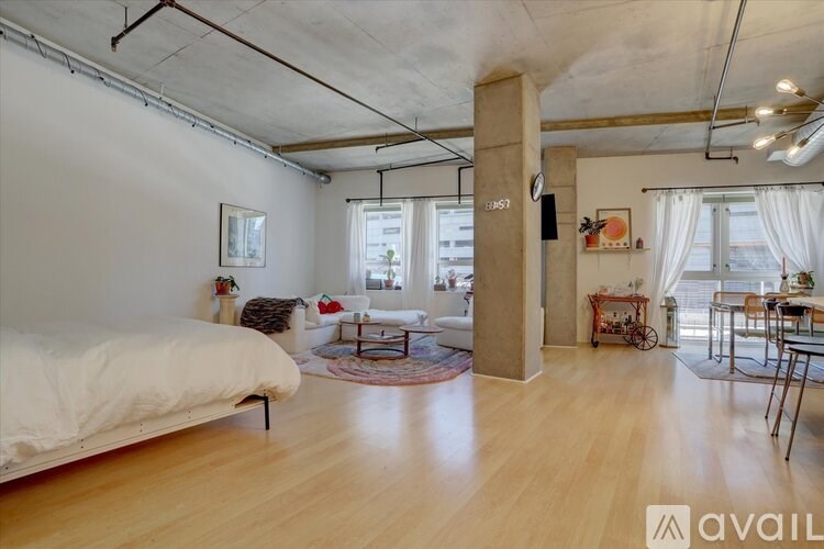 A bedroom with a large bed and a living area with a couch and chairs.