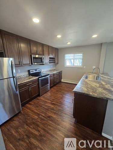 A kitchen with wooden cabinets and a granite countertop.