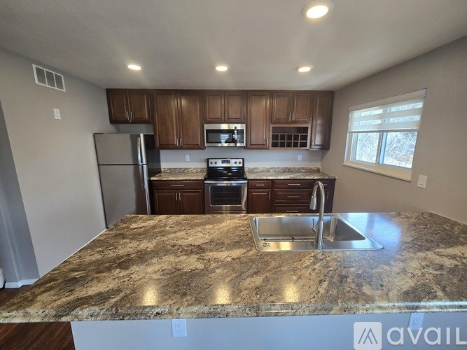 A kitchen with granite countertops and stainless steel appliances.