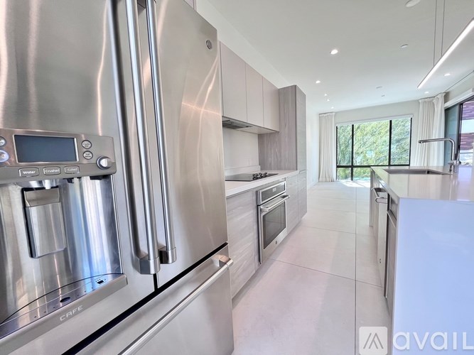 A modern kitchen with stainless steel appliances and white cabinets.